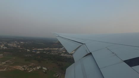 wing of airplane landing on airport runway
