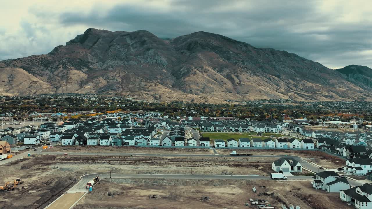 Utah Valley's new housing development against Mount Timpanogos in autumn. Overcast skies highlight the vibrant fall landscape in American Fork, Utah