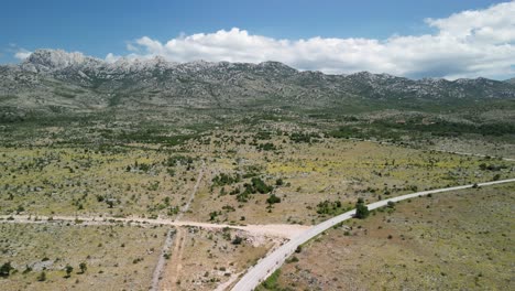 Región-Kárstica-árida-De-La-Montaña-Velebit-En-El-Condado-De-Zadar-En-Verano,-La-Vista-Desde-Arriba-Sobre-La-Carretera-Y-Archivada-Con-El-Horizonte-Bloqueado-Con-La-Cordillera