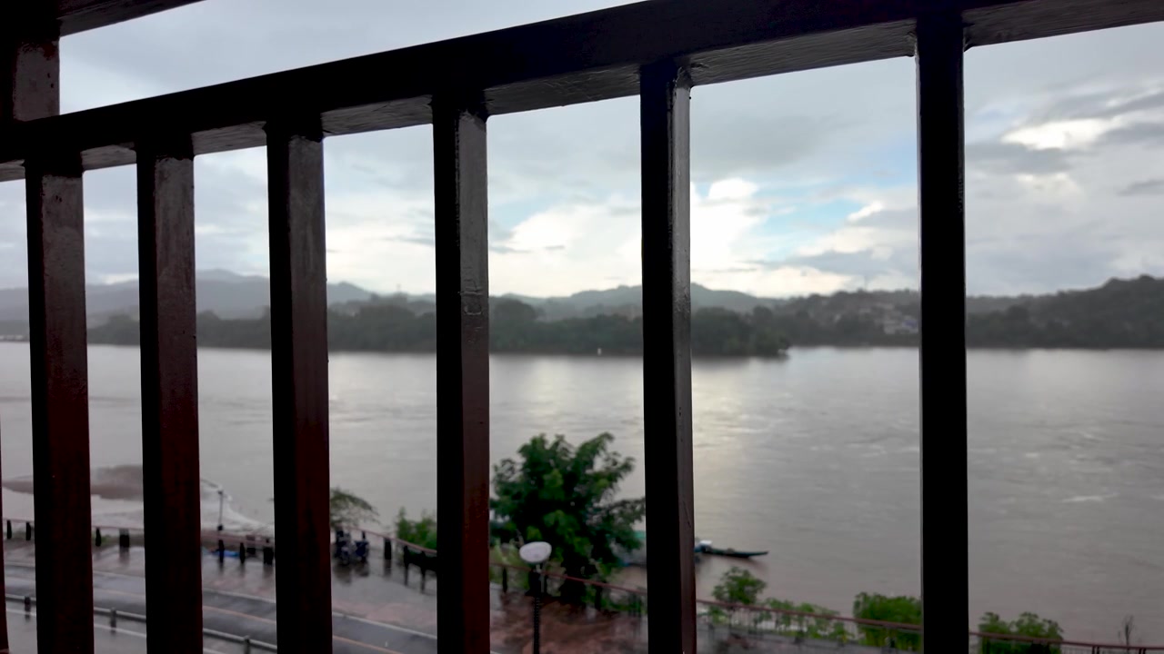 View of the Mekong River through a railing in Chiang Khong on overcast day