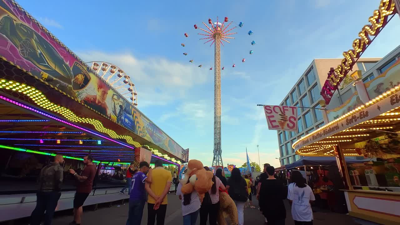 Slo-mo walking scene in busy amusement park on sunny summer day, Germany