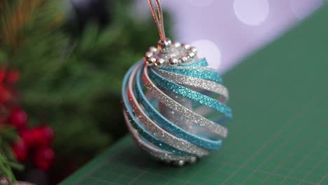 Blue-and-silver-glitter-foam-christmas-ornament,-on-a-green-cutting-mat