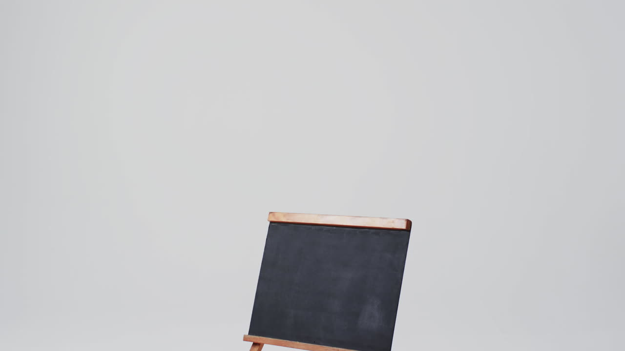 Video of blackboard sign on wooden stand with copy space on white background