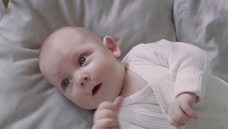 top view of newborn baby lying on bed and looking away