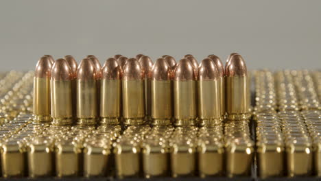 dolly of bullets standing on boxes of ammunition against a white background