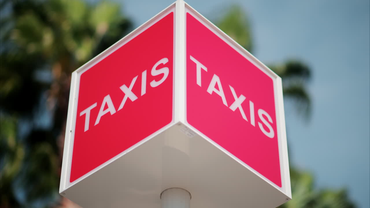 Red taxi sign with a blurry view on the street in Cannes, France