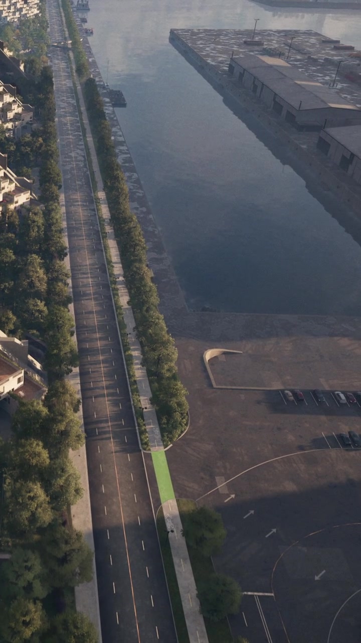 Percorso pedonale lungo un fiume in una città con edifici e parcheggi nelle vicinanze.