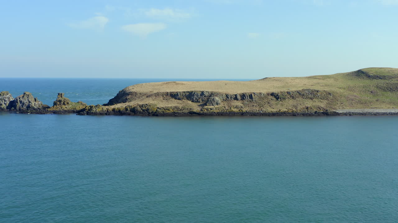 Aerial view of Portmurk Island headland as drone moves forward with downward tilt