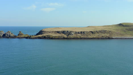aerial view of portmurk island headland as drone moves forward with downward tilt