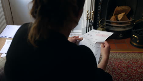 an unrecognizable female opening a debt letter