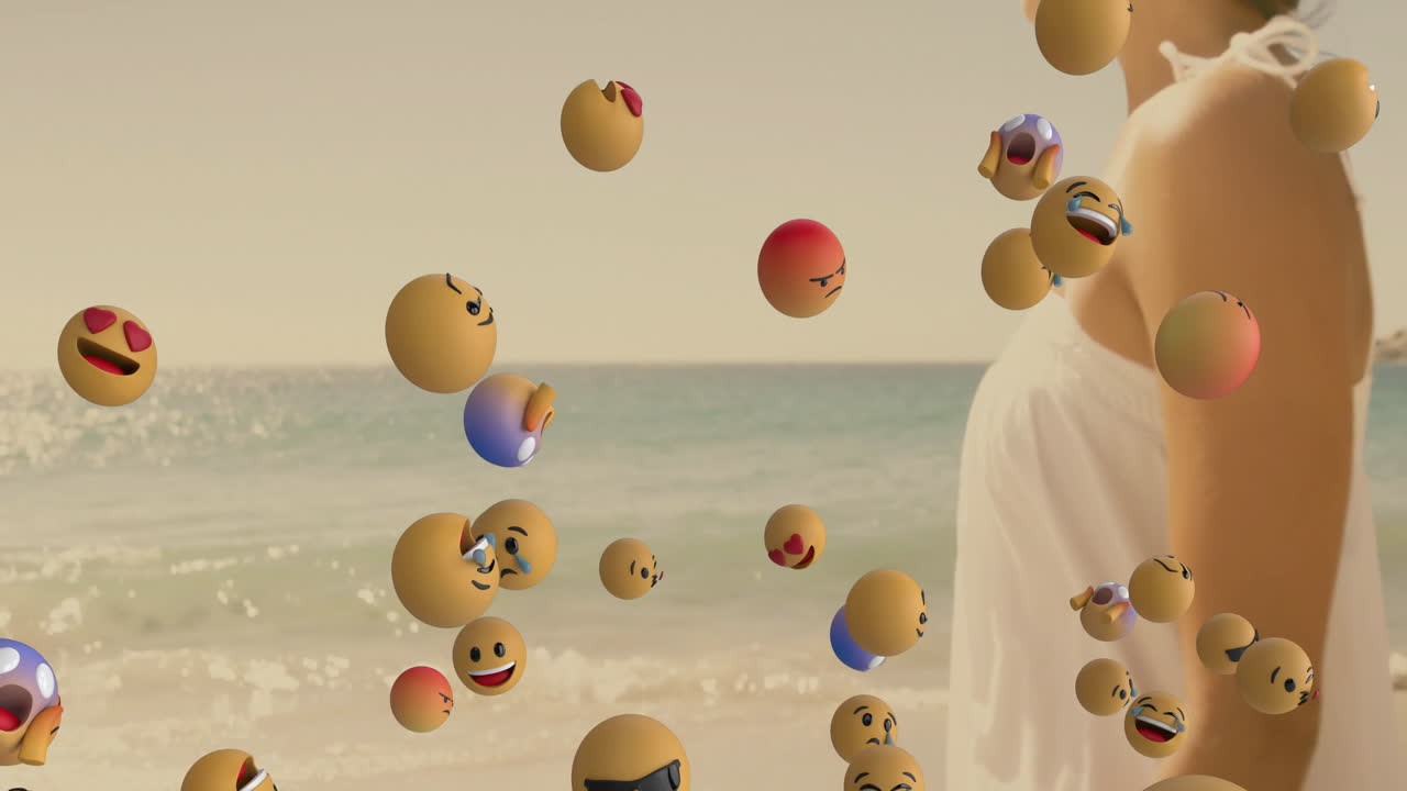 Standing by ocean, woman surrounded by floating animation of smiling emojis