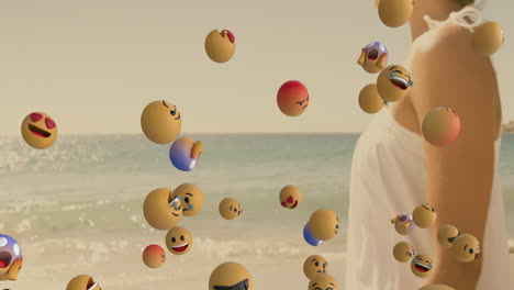 standing by ocean, woman surrounded by floating animation of smiling emojis