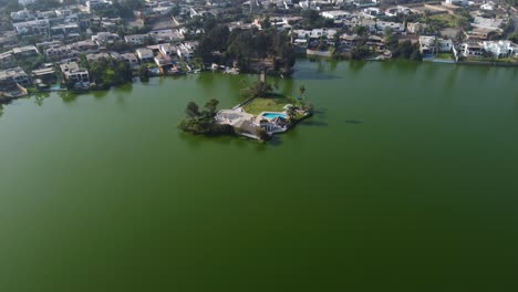 drone video of a lagoon or lake with a small island in the middle connected by a bridge to land