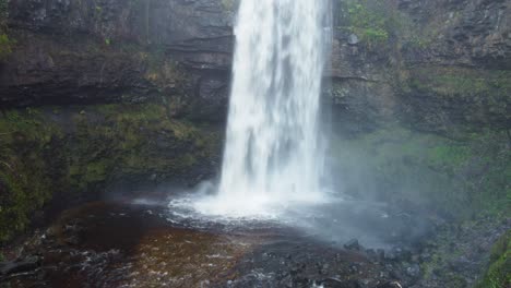 disparo aéreo de drones de empuje lento de una espectacular cascada en gales, reino unido 4k