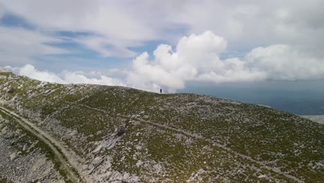 beautiful landscape on top of mountains with rocks in the foreground green grass with trees, clouds visible in the background