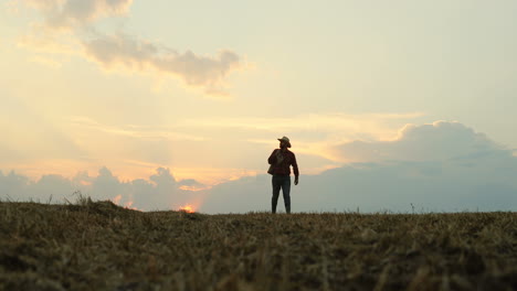 caucasian farmer carrying a sack full of grainin the field