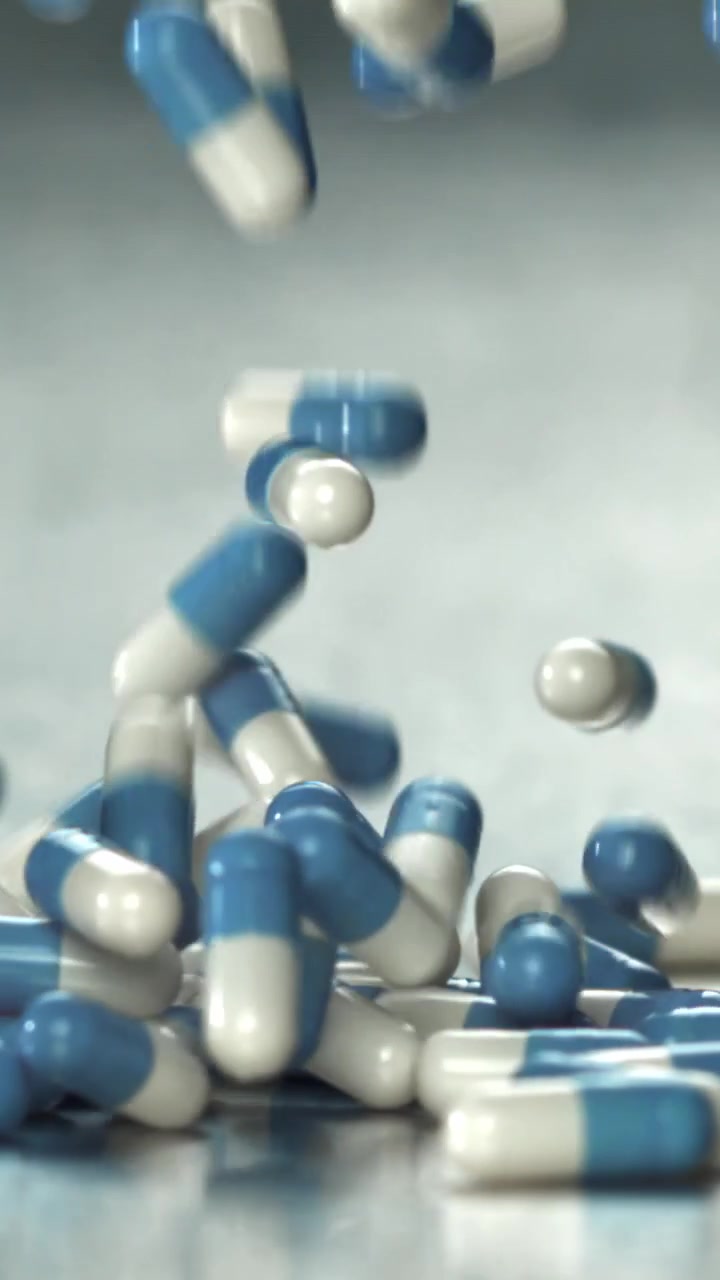 Capsule mediche blu e bianche che cadono al rallentatore