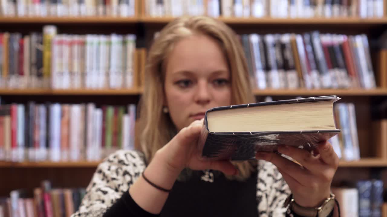 bella joven está cerrando un libro abierto, toma lateral, mirada dominante