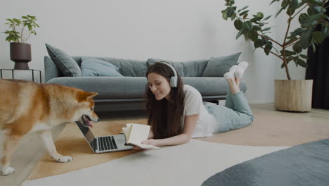 Cute-Girl-Plays-With-Her-Dog-While-Working-On-Her-Laptop-At-Home-1