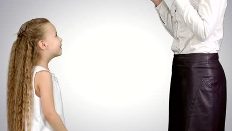 little girl giving a gift to her mother and kissing on white background