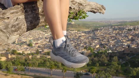 Balanceo-De-Piernas-Moviéndose-De-Una-Mujer-Joven-Sentada-En-Un-árbol-En-El-Mirador-De-Fez