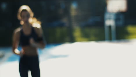 숨을 쉬기 위해 쉬고 여름날 스포츠 코트에서 계속 달리는 스포티 한 소녀