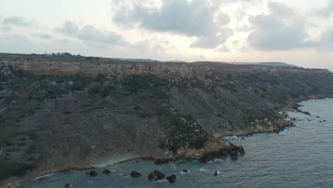 Shoreline-of-Gozo-Malta-Island-at-Sunset,-Ocean-Waves-from-Aerial-Drone-Perspective