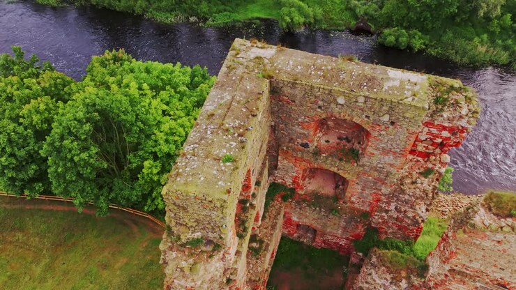 Drone cattura le rovine delle mura del castello di Bauska con i piccioni sopra il fiume Memele