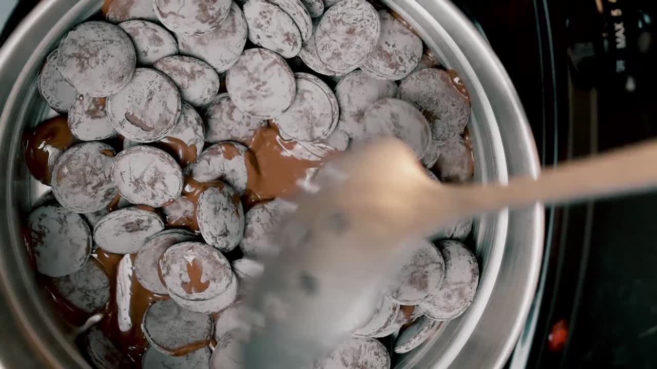 vista superior en un crisol de rondas de dulces de chocolate con leche que se revuelven con una cuchara