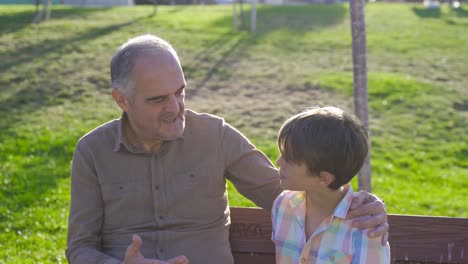 abuelo nieto charlando al aire libre.