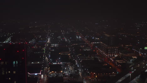 Forwards-fly-above-night-city.-Long-straights-streets-lined-by-street-lights.-Aerial-view-of-urban-neighbourhood.-Dallas,-Texas,-US