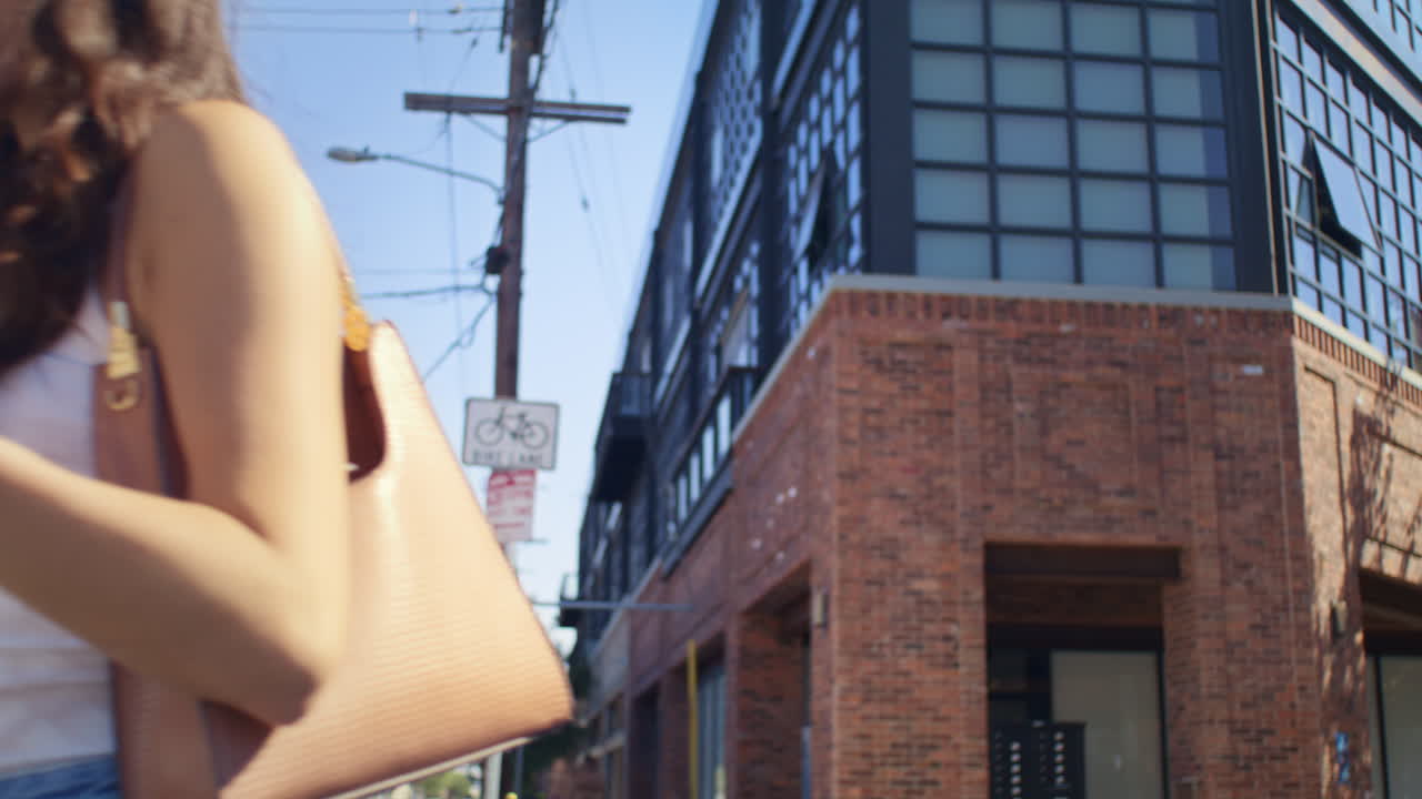 길거리 클로즈업에서 누군가에게 손을 흔들고 있는 아시아 소녀. 걸어서 친구들을 만나는 여자.