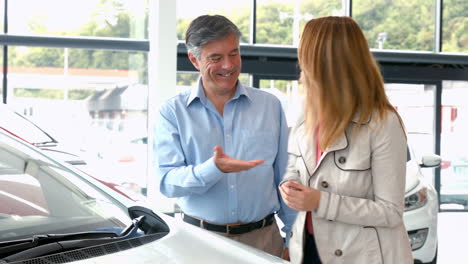 couple taking keys from businessman