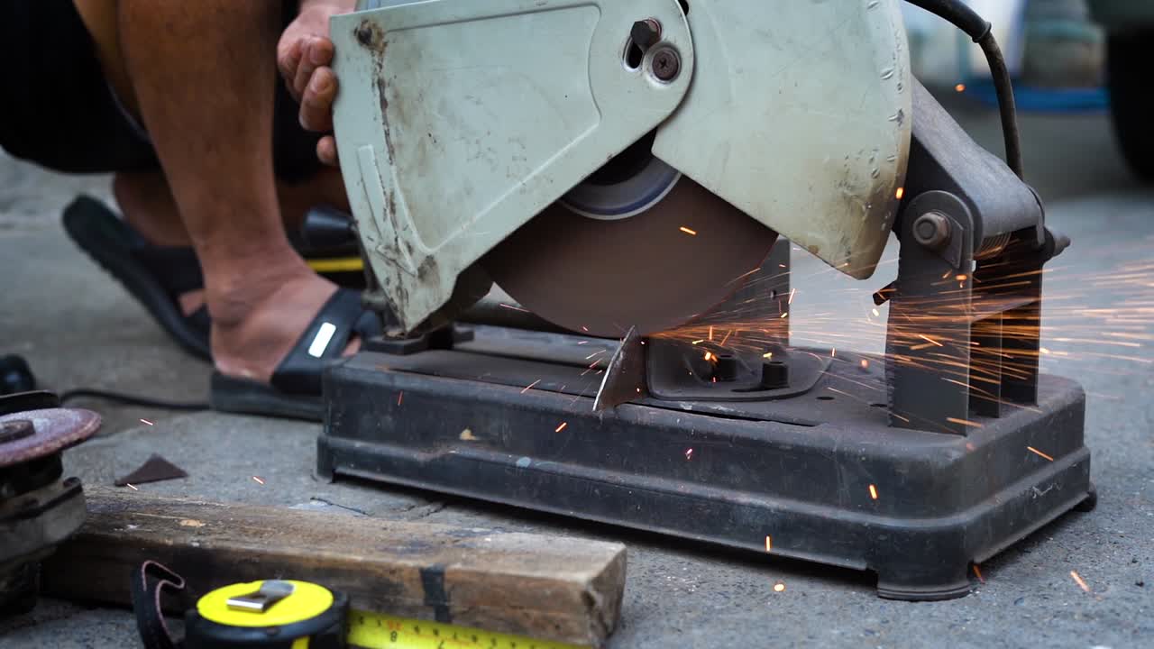 un trabajador de la construcción corta accesorios metálicos con una molienda.