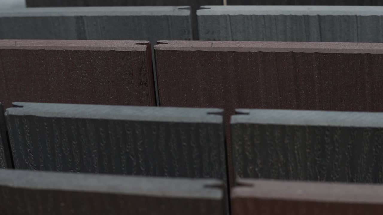 Multi-colored wooden deck tiles with "Easy Deck" written on them, neatly arranged. Ideal for themes of home improvement, outdoor spaces, and modern decking solutions.