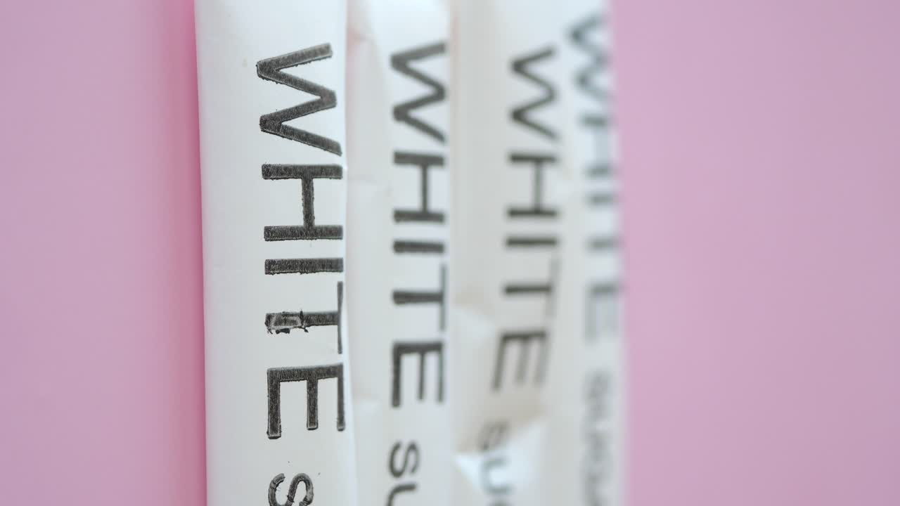 White Sugar Packets on Pink Background