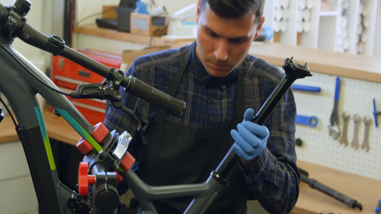 hombre reparando una bicicleta en el taller 4k