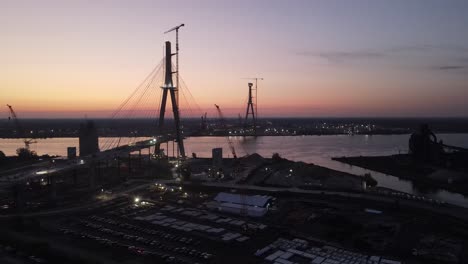 silhouette of international bridge of gordie howe construction site during sunset, aerial view