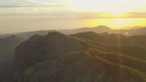 Hermosa-Foto-De-Un-Dron-De-Un-Panorama-De-Montaña-A-La-Hora-Dorada-Con-Un-Bosque-Y-Un-Destello-De-Lente,-Gran-Canaria