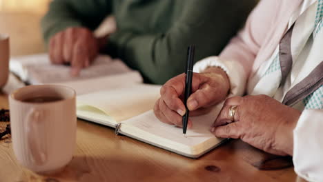 elderly couple writing in a notebook
