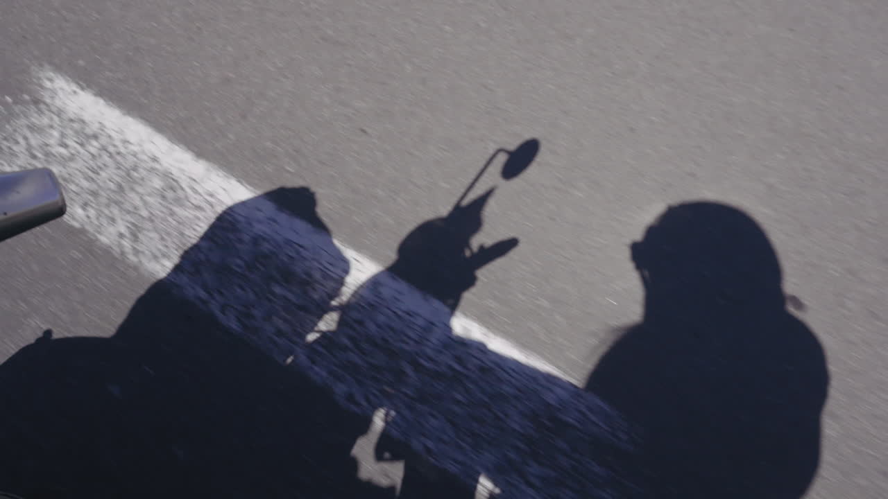 Biker shadow traveling on road. Travel concept. Real time, high angle