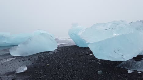 Wandern-Zwischen-Großen-Gletschereisstücken,-Die-Am-Black-Diamond-Beach-In-Südisland-Ausgewaschen-Wurden