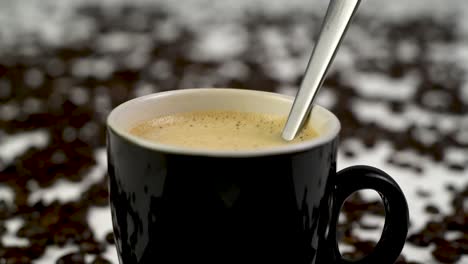 steady shot of someone stirring a cup of coffee