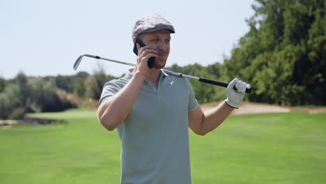 hombre hablando por teléfono mientras juega al golf
