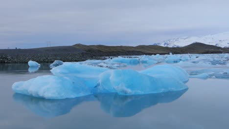 Un-Hermoso-Iceberg-Blanco-Azulado-Flotando-En-Un-Lago-En-Islandia---Toma-Amplia