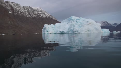 Iceberg-in-Cold-Sea-Water-Under-Snow-Capped-Hills-in-Norwegian-Fjord