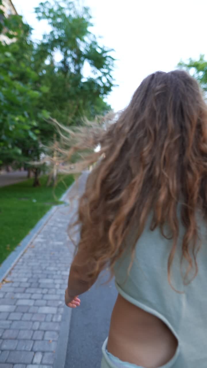Donna che cammina per una strada cittadina con un abito verde chiaro