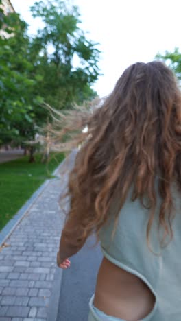 woman walking down a city street in a light green dress