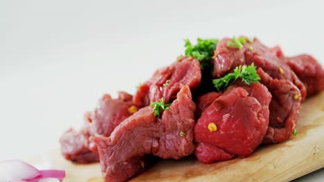 marinate beef pieces on wooden board