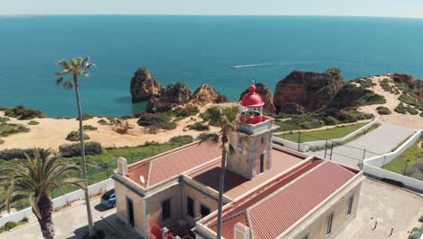 Close-view-of-Ponta-da-Piedade-Lighthouse-over-stunning-headland-in-Lagos,-Algarve,-Portugal---Aerial-close-Orbit-Point-of-interest-shot